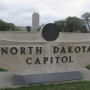 La torre del Capitolio de Dakota del Norte se eleva en el fondo detrás de una señal de piedra en Bismarck, Dakota del Norte, el 19 de abril de 2012.