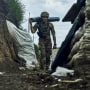 A Ukrainian soldier carries supplies in a trench at the frontline near Bakhmut on May 22, 2023.
