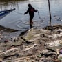 A fisherman docks his boat at a beach filled with plastic waste at Freedom Island in Paranque, Philippines on April 19, 2023.