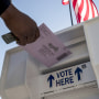 A voter drops an early voting ballot into a collection box in Martinez, Calif., on Oct. 27, 2020.