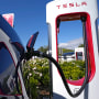 A Tesla auto charges at a charging station
