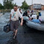 Rescatistas intentan remolcar botes para llevar a vecinos evacuados de un vecindario inundado en Kherson, Ucrania, el martes 6 de junio de 2023.
