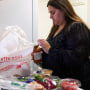Jaqueline Benitez guarda las compras en su casa en Bellflower, California, el lunes 13 de febrero de 2023. Benitez, de 21 años, quien trabaja como maestra de preescolar, depende de los beneficios de SNAP de California para ayudar a pagar los alimentos.