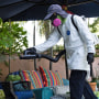 A Miami-Dade Mosquito Control Inspector sprays pesticide to kill adult mosquitos on June 29, 2023.