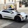 Waymo communications manager Julia Ilina stands next to a Waymo driverless taxi that stopped in the street because the back door was not completely shut, while traffic backed up behind it, in San Francisco, on Feb. 15, 2023. 