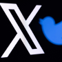 The new Twitter logo rebranded as X and the old Twitter bird logo reflected in smartphone screens.