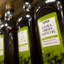 Rows of Tesco brand olive oil on a supermarket shelf in England.