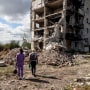Two women look at an apartment block in Izium, Ukraine, ruined in the shelling of Russian troops on the first anniversary of the liberation of the city from Russian invaders, on Sept. 20, 2023.