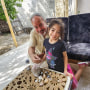Hamed Alhayek, 72, sits with his granddaughter Alya Alhayek going through shells she picked up from the beach in their home in the northern part of the Gaza strip this past summer.