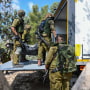 Soldados israelíes retiran cadávers de de civiles en un asentamiento cerca de la Franja de Gaza, en Kfar Aza, en Israel, el 10 de octubre de 2023.
