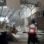 A security guard walks beside the damaged ceiling of a shopping mall in General Santos City, Philippines,