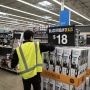 A worker stocks vacuums at a Walmart store on Black Friday in Secaucus, N.J., on Nov. 24, 2023.