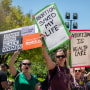 Protesters hold signs at a rally at the Texas Capitol in Austin.
