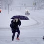 A pedestrian navigates a snow-covered sidewalk on Jan. 9, 2024 in Iowa City, Iowa. 