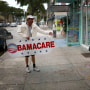 Man holding "Obamacare" sign.