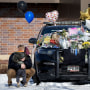 Zach Osterberg, of the Savage Fire Department, hugs his son Lincoln as they paid their respect at three memorials in front of the Burnsville Police Department in Burnsville, Minn., Monday, Feb. 19, 2024. Two police officers and a first responder were shot and killed early Sunday and a third officer was injured at a suburban Minneapolis home in an exchange of gunfire while responding to a call involving an armed man who had barricaded himself inside with family. 