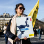Image: A woman holds a poster of human rights group of 'Amnesty International' bearing the word "Victory" on a uterus drawing