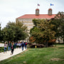 Students walks in front of Fraser Hall on the University of Kansas campus 
