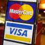 En esta foto de archivo del 22 de abril de 2005, se muestran los logotipos de las tarjetas de crédito MasterCard y Visa en la entrada de un café en Nueva York. 