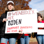 Activists hold up signs as they listen during a Title IX rally near the White House.