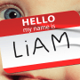Photo illustration of a close-up of a baby's face; overlaid with a "Hello my name is Liam" sticker