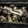 Charlize Theron and Tom Hardy pointing guns in a scene from the movie