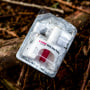 A container of Narcan, or naloxone, sits on tree roots 