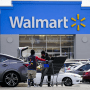 A Walmart employee helps a customer outside the Walmart store.