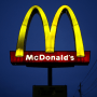Signage stands outside a McDonald's restaurant at night