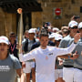 French trail runner Paul Mathou runs with the flame during the Olympic torch relay.