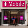 Person walking past a T-Mobile store in New York.