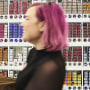 An employee passes in front of hair dye products on display inside an Ulta Beauty store