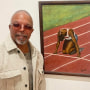 Alonzo Adams posing in front of his first oil panting, The Start.