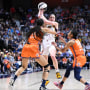 Caitlin Clark of the Indiana Fever passes the ball against Olivia Nelson-Ododa, left, and Tyasha Harris of the Connecticut Sun