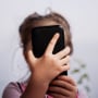 Close-up of child using mobile phone. 