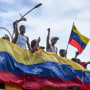 Protesters demonstrate holding the flag of Venezuela