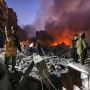 Lebanese army soldiers gather over the rubble of a levelled building as people flight the flames,