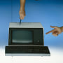 Human hands pointing at vintage computers