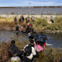 Migrants, predominantly from Venezuela, cross the Rio Grande 