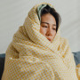 Sick person under the blanket on sofa in living room at home.