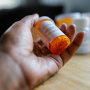 Woman Holds Bottle of Prescription Medication