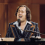 Neil Sedaka plays the piano and sings.