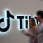 Web Summit attendees walk past the TikTok pavilion