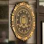 The exterior of a government building with the DOJ seal on its facade.