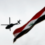 A U.S Army helicopter flies over an Iraqi flag