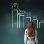 Image: Businesswoman looking at a financial chart on chalkboard