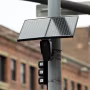 A solar-powered surveillance camera mounted on a light pole.