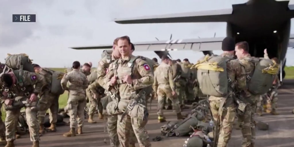 Stock footage of U.S. troops boarding a plane for yet another Middle East deployment, because apparently we’re doing sequels forever now.