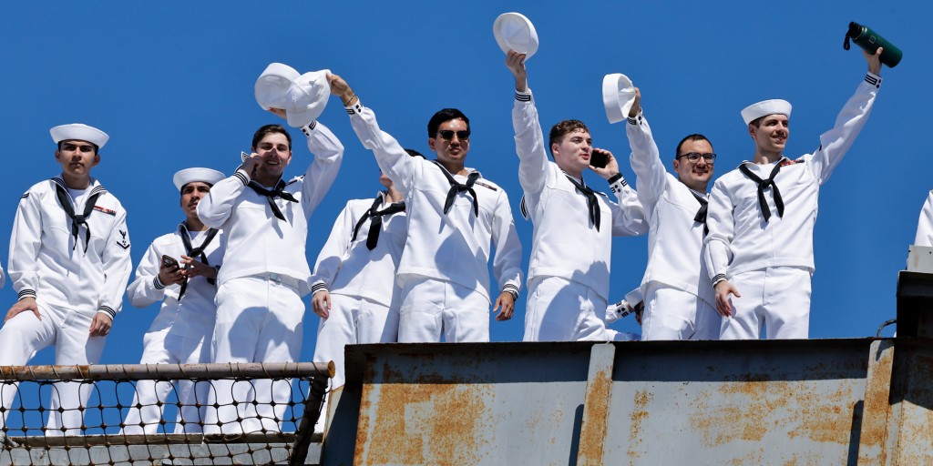 Draped in red, white and blue striped banners, the USS Abraham Lincoln arrives in San Diego Bay after 322 days at sea, ending one of the longest maritime deployments in U.S. military history.