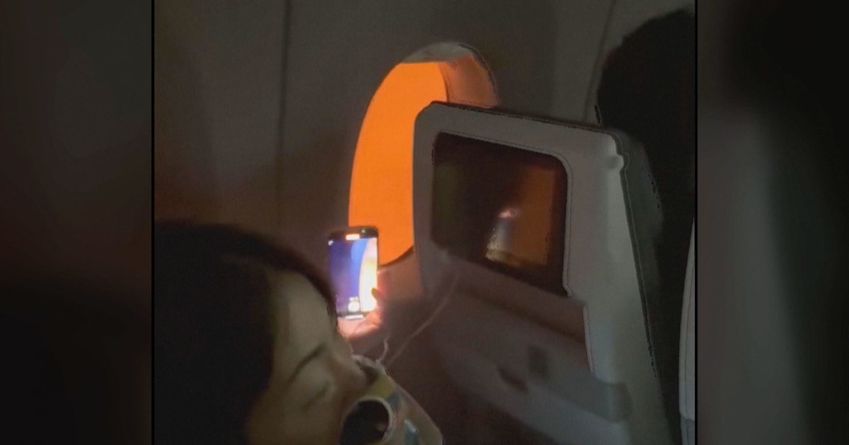 shows passengers stuck on burning Japan Airlines plane in Tokyo